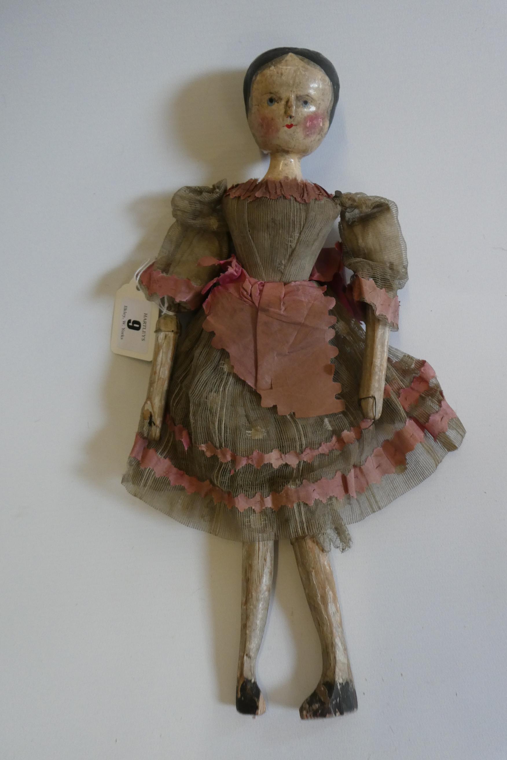 A Victorian peg doll with carved and painted head and torso, cloth upper limbs and carved wooden Image
