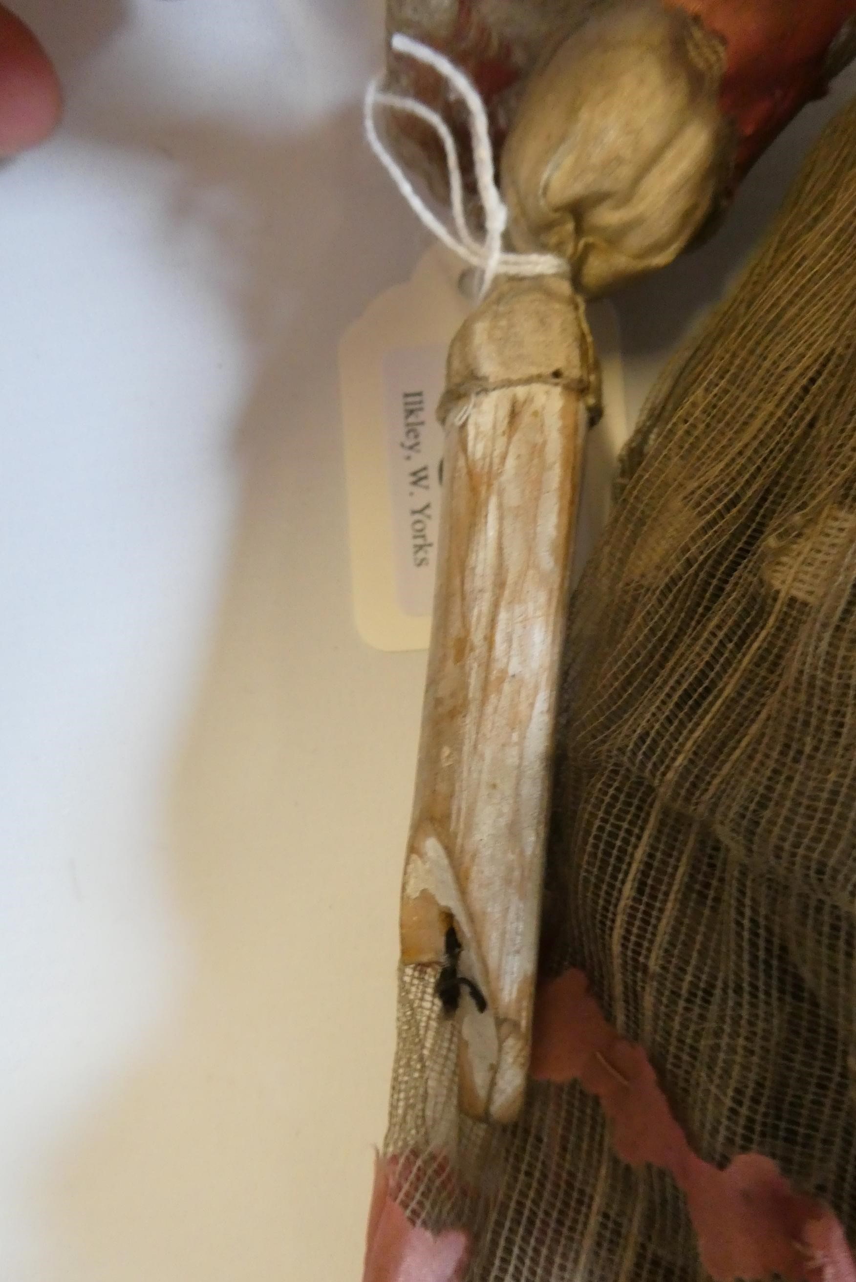 A Victorian peg doll with carved and painted head and torso, cloth upper limbs and carved wooden Image