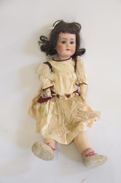 A Schoenau & Hoffmeister bisque head doll with blue glass sleeping eyes Image