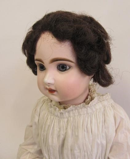 A Bebe Jumeau bisque head doll with fixed blue glass paperweight eyes Image