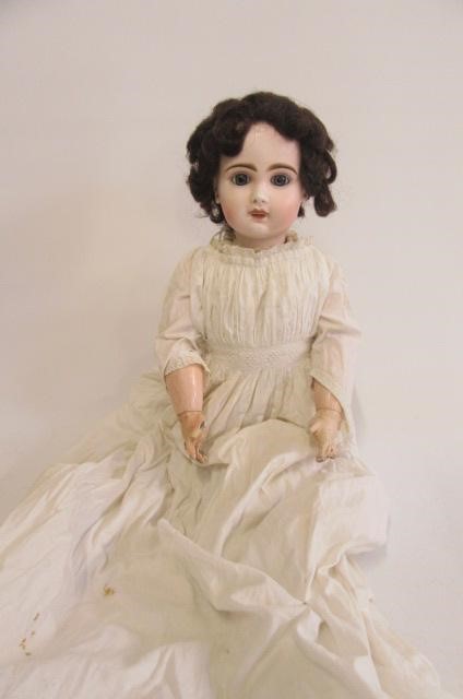 A Bebe Jumeau bisque head doll with fixed blue glass paperweight eyes Image