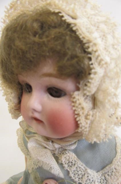 An Armand Marseille bisque head doll with brown glass sleeping eyes Image
