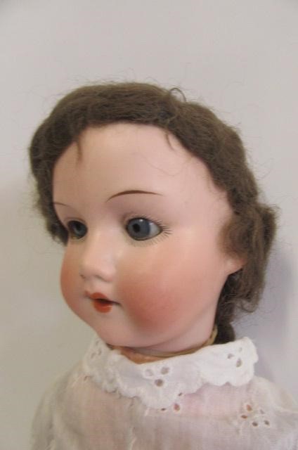 An Armand Marseille bisque head doll with blue glass sleeping eyes Image