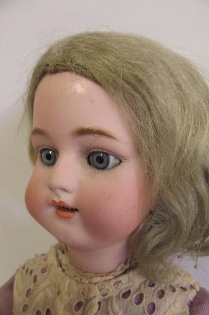 A Simon & Halbig bisque head doll with blue glass sleeping eyes Image