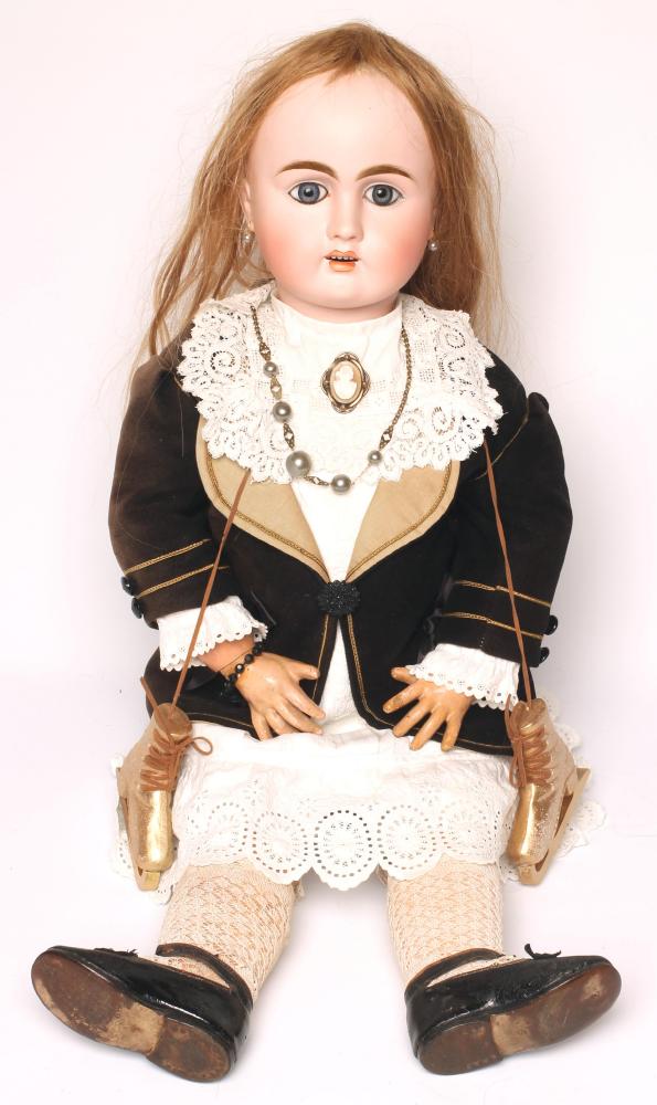 A French Bebe bisque head doll with fixed blue paperweight glass eyes Image