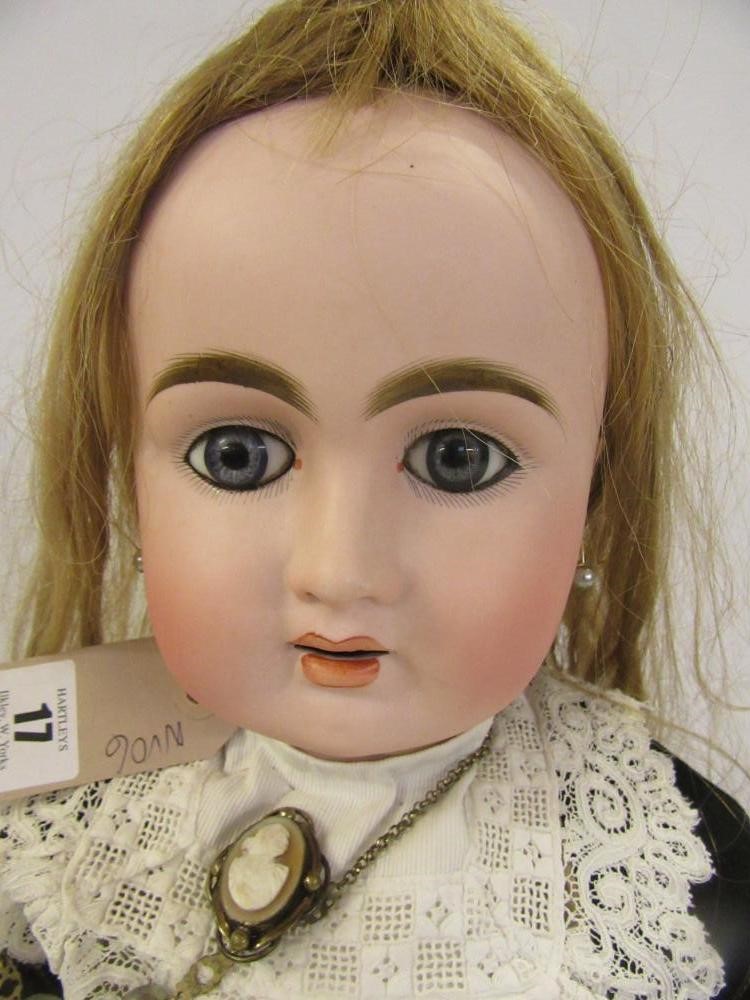 A French Bebe bisque head doll with fixed blue paperweight glass eyes Image