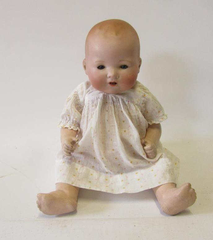 An Armand Marseille bisque head baby doll with blue glass eyes Image