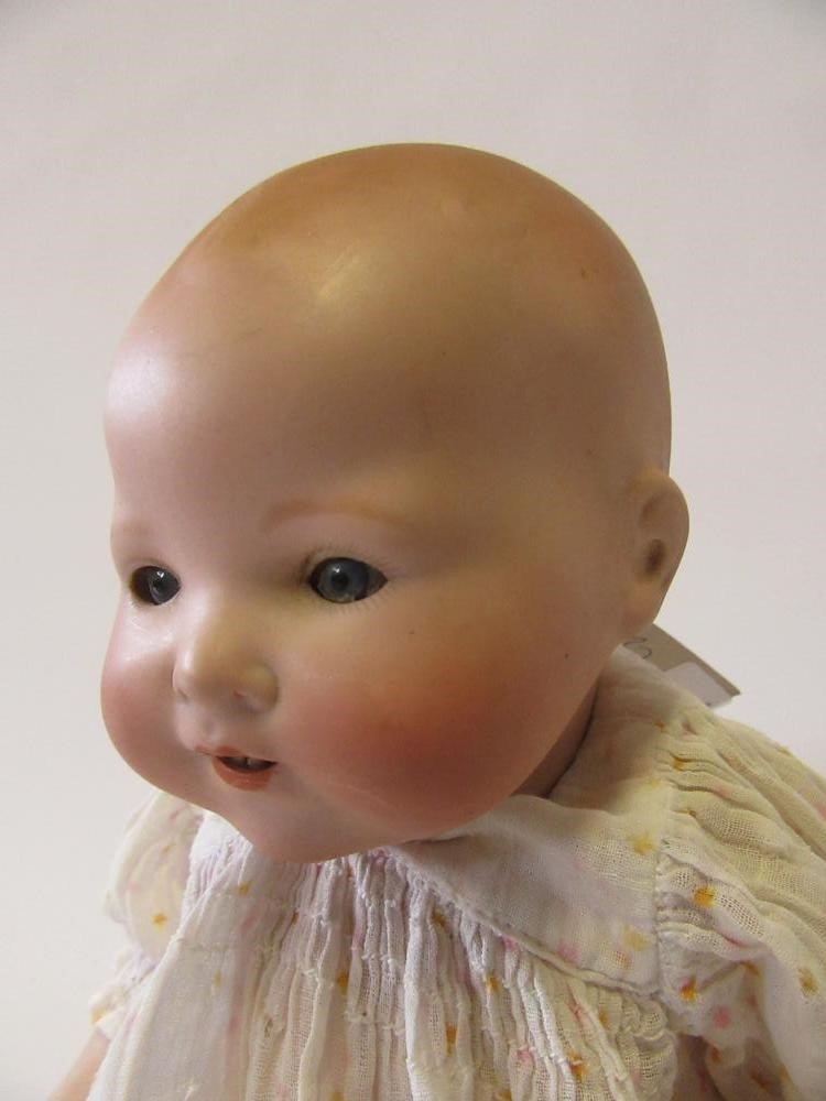 An Armand Marseille bisque head baby doll with blue glass eyes Image