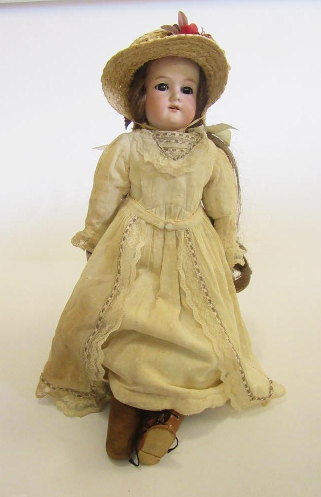 An Armand Marseille bisque shoulder head doll with brown glass sleeping eyes Image