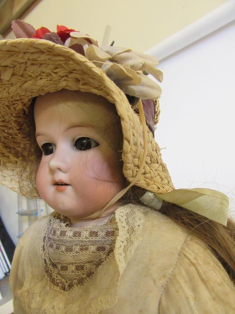 An Armand Marseille bisque shoulder head doll with brown glass sleeping eyes Image