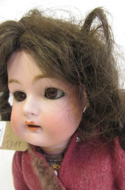 A Kammer & Rheinhardt bisque head doll with brown glass sleeping eyes Image