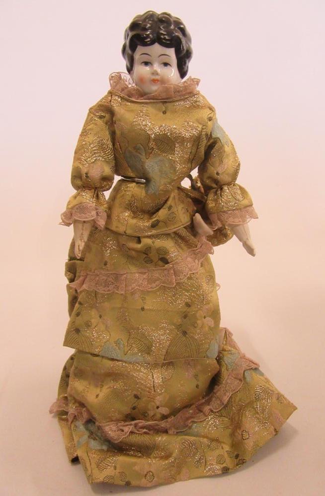 A china shoulder head doll with painted face and hair Image
