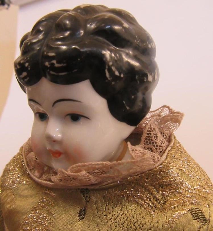 A china shoulder head doll with painted face and hair Image