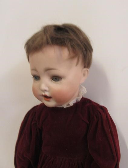 A Kestner bisque head character doll with blue glass sleeping eyes Image