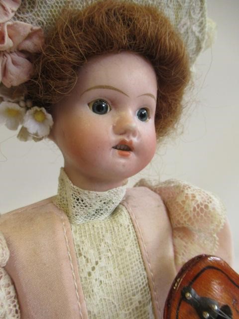 A bisque head automaton doll under dome Image