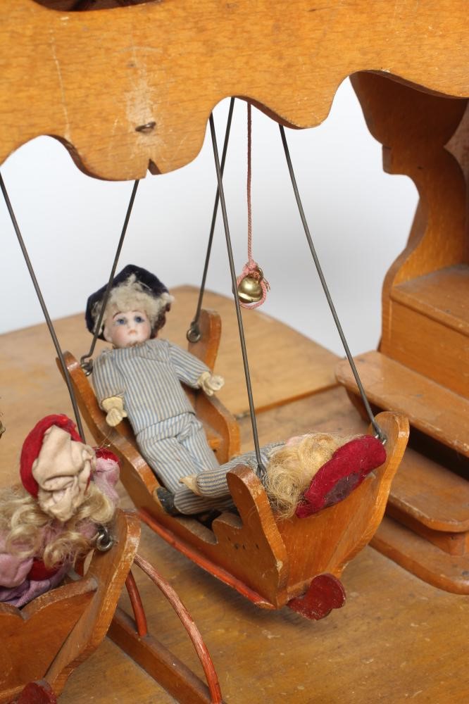 An early 20th century musical doll's swing boat set ensuite with six French dolls Image
