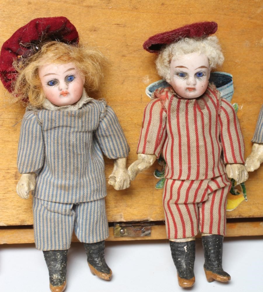 An early 20th century musical doll's swing boat set ensuite with six French dolls Image