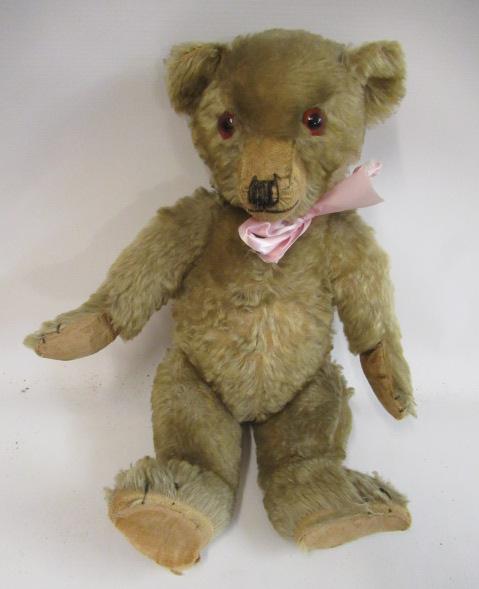 An English teddy bear, possibly Farnell, with amber glass eyes, sewn nose, shaved snout, orange Image