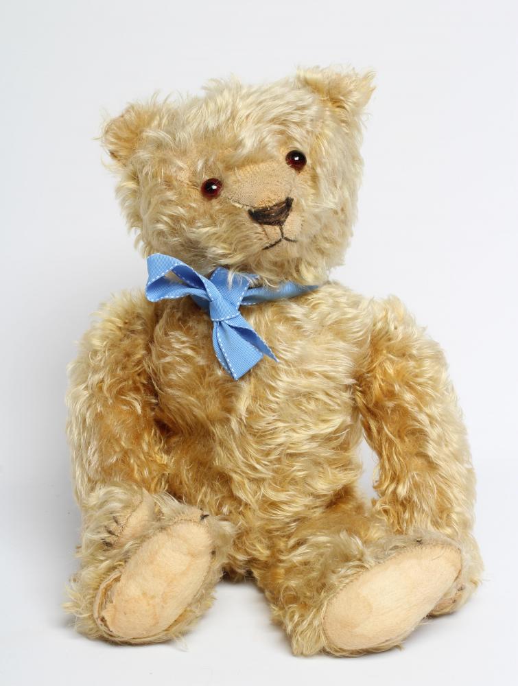 A pre-war teddy bear, with amber glass eyes, sewn nose, long orange plush and felt pads, 19 1/2" Image