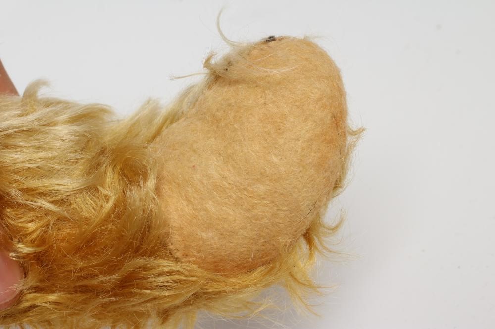 A pre-war teddy bear, with amber glass eyes, sewn nose, long orange plush and felt pads, 19 1/2" Image