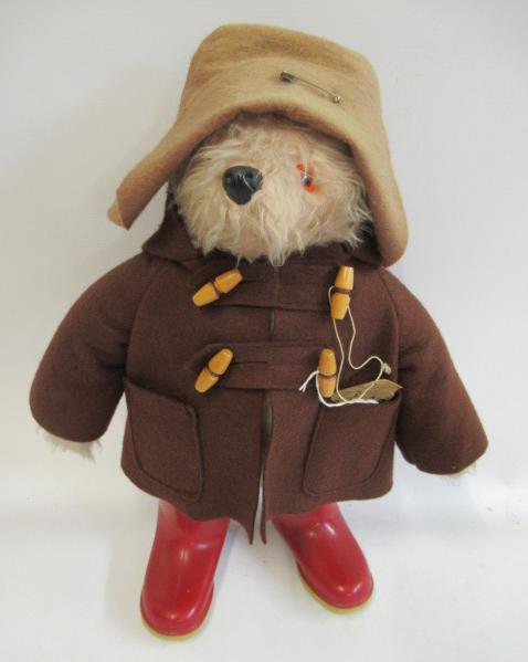 Paddington bear, with brown felt coat, hat, label and red Dunlop boots (Est. plus 24% premium inc. Image