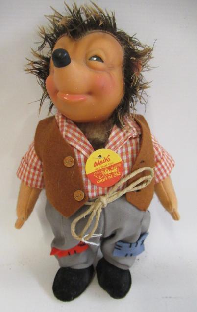 A Steiff Mecki, with celluloid face, felt arms, clothing, brass button, label and card tag, 25cm Image