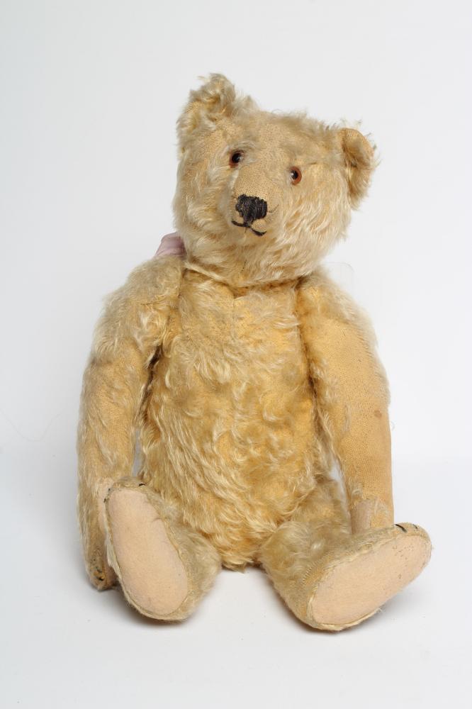 An early Steiff teddy bear, with amber glass eyes, sewn nose, felt pads, orange plush and button to Image