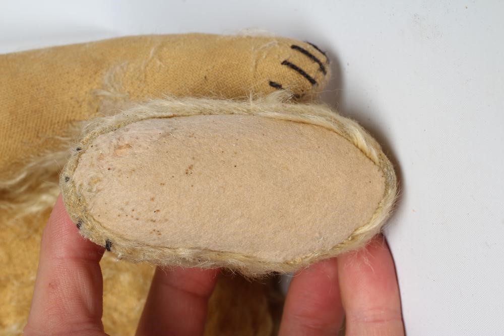 An early Steiff teddy bear, with amber glass eyes, sewn nose, felt pads, orange plush and button to Image