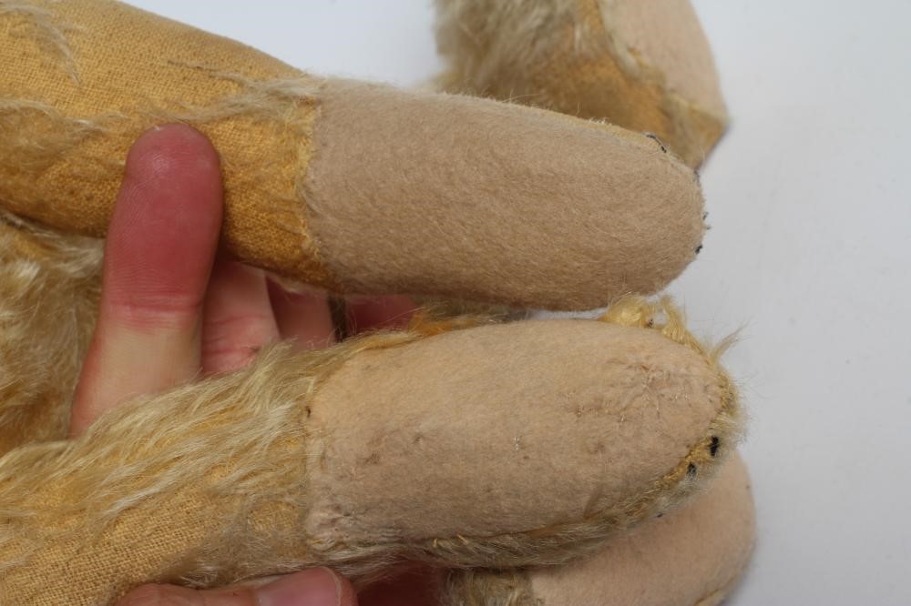 An early Steiff teddy bear, with amber glass eyes, sewn nose, felt pads, orange plush and button to Image