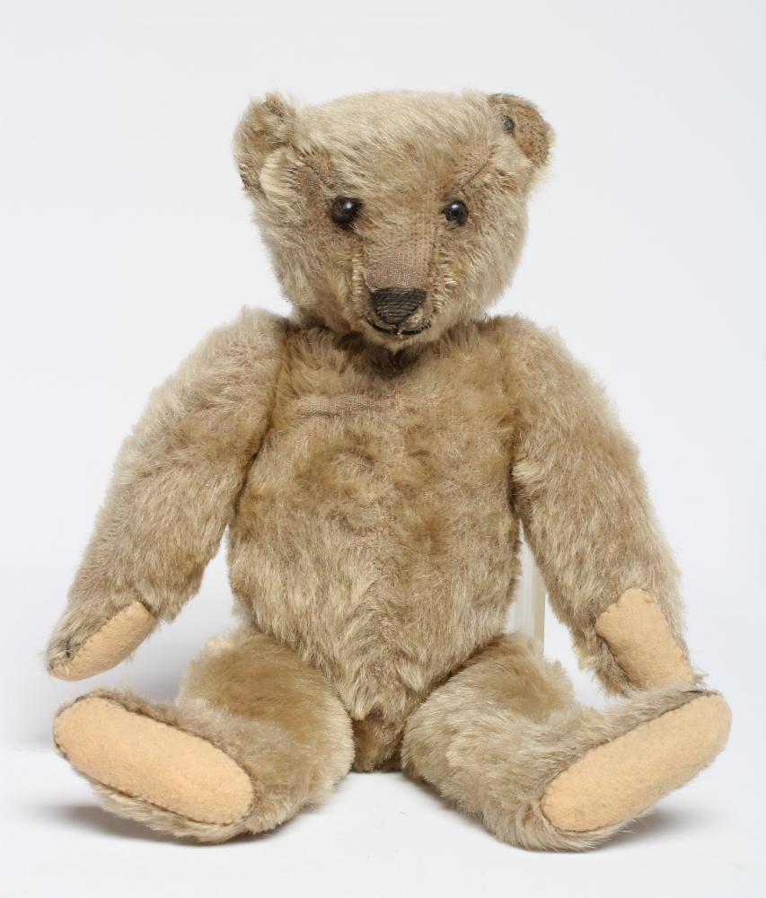 An old Steiff teddy bear, with black button eyes, sewn nose, replaced felt pads, light orange plush Image