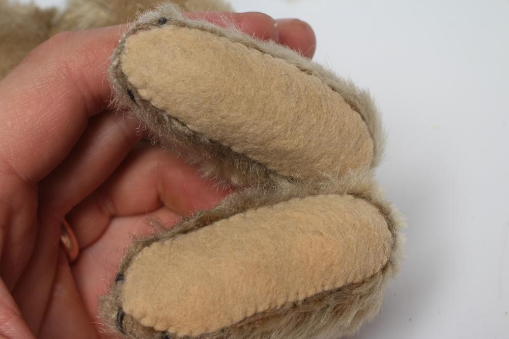 An old Steiff teddy bear, with black button eyes, sewn nose, replaced felt pads, light orange plush Image