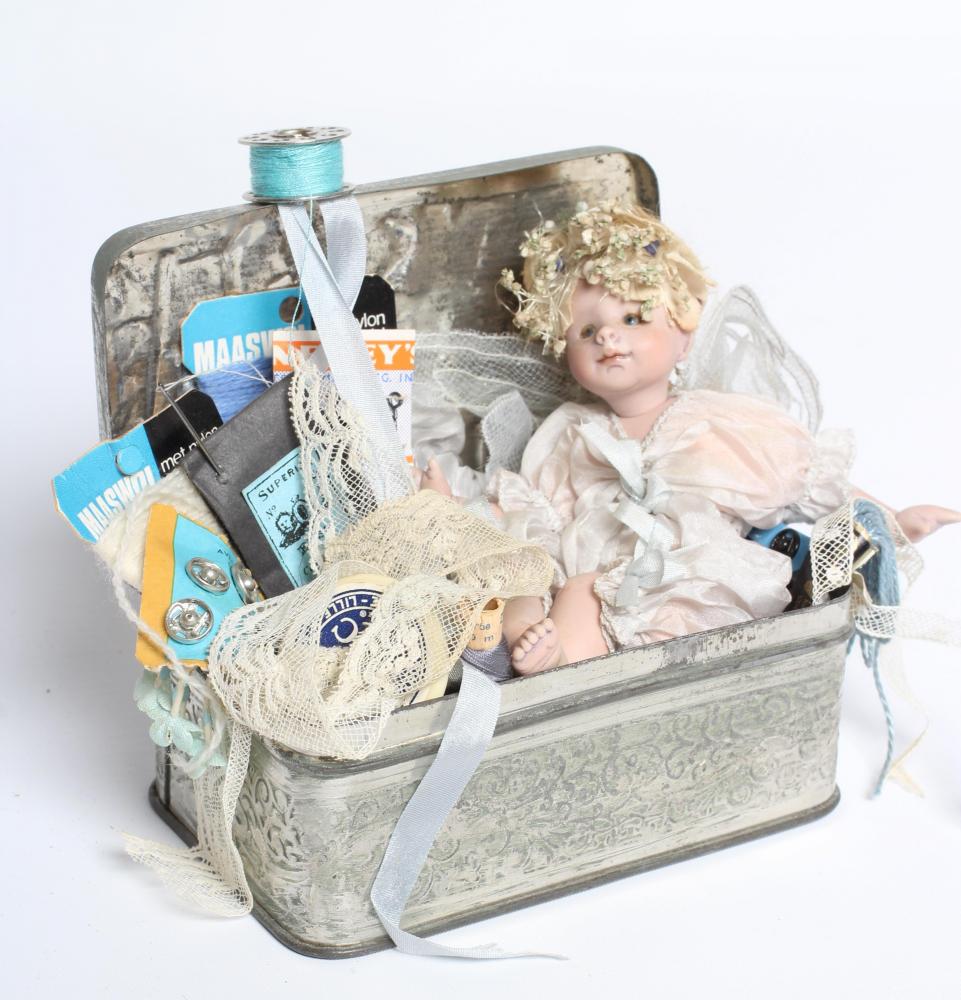 A Gerda Schaarman doll display, depicting a fairy with bisque head and limbs, sat within a Image