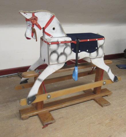 A vintage rocking horse, of wood box construction, with dappled grey paint, fabric saddle and swung Image
