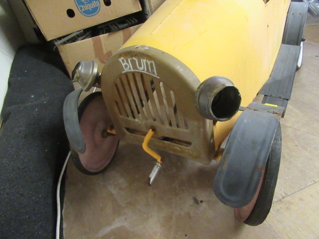 A vintage brum pedal car of metal construction with classic yellow body paint forward crank Hartleys Auctioneers Valuers