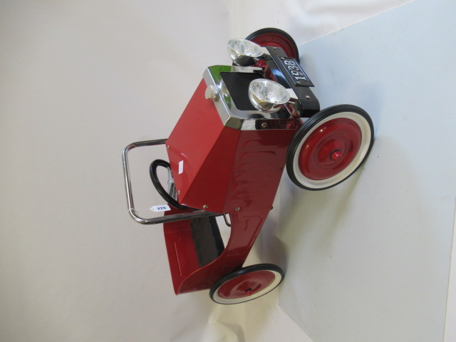 A reproduction pedal car, in the 1930s style, of metal construction painted in red, with two tone Image