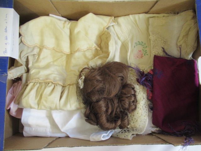 A collection of good quality dolls clothing and a brown wig for a 15" head (Est. plus 24% premium Image