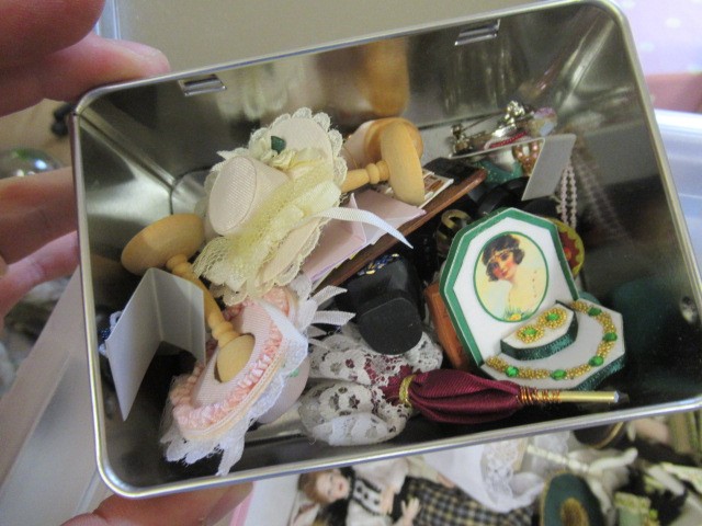 A box of dolls house furniture, including wooden furniture, two metal and wood construction sewing Image