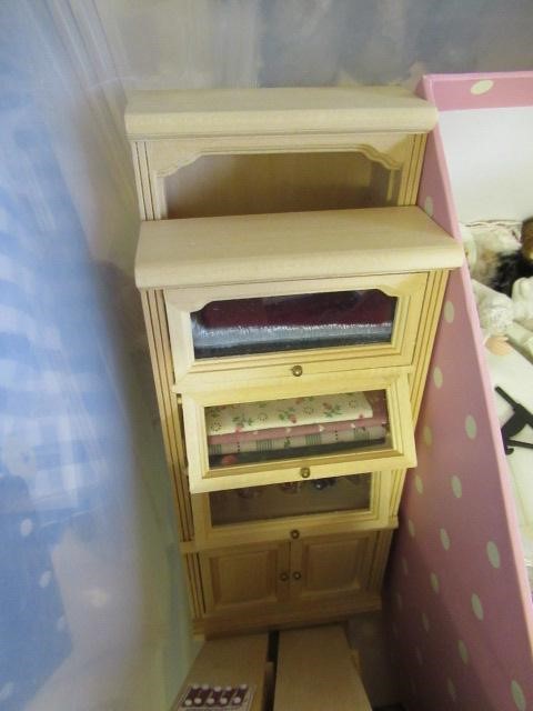A box of dolls house furniture, including wooden furniture, two metal and wood construction sewing Image