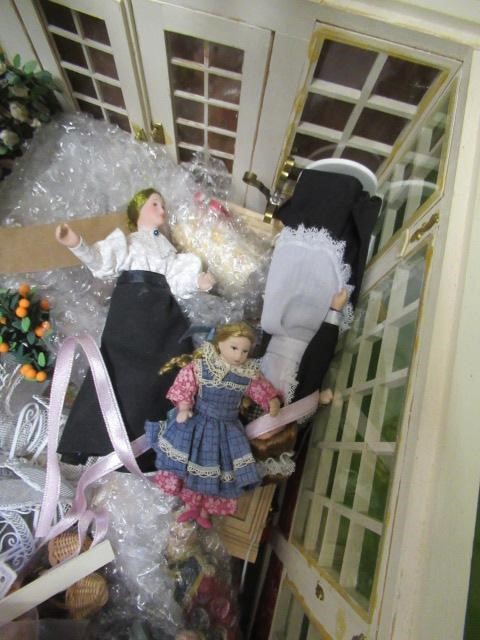 A box of dolls house dolls and outside accessories, including a conservatory, wire work pagoda and Image