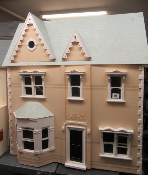 A Victorian style "Dolls House Emporium" dolls house, with two hinged openings revealing seven Image