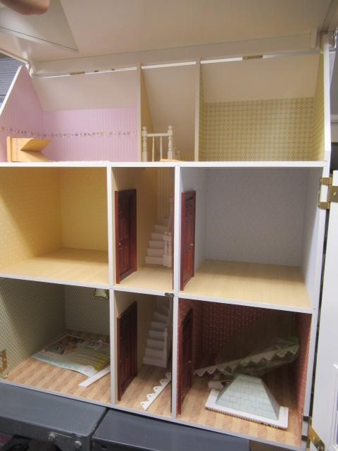 A Victorian style "Dolls House Emporium" dolls house, with two hinged openings revealing seven Image