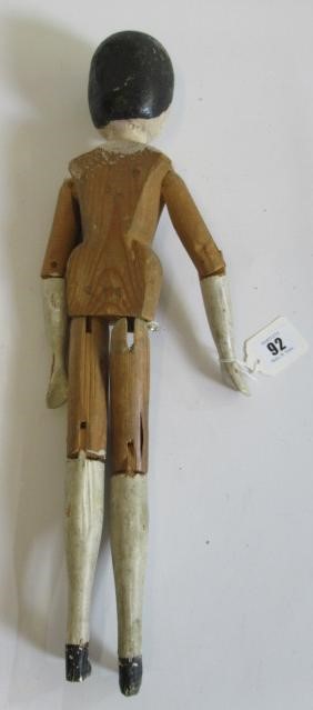 A large Victorian peg doll, of all wood construction with painted face and hair, painted lower Image