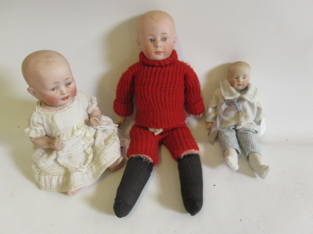 Three bisque head solemn boy dolls Image