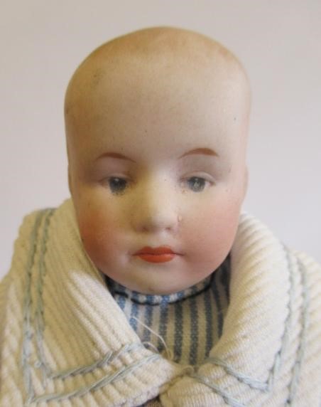 Three bisque head solemn boy dolls Image