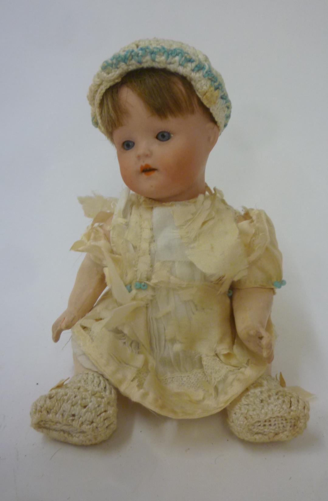 A small German bisque head doll with blue glass sleeping eyes Image