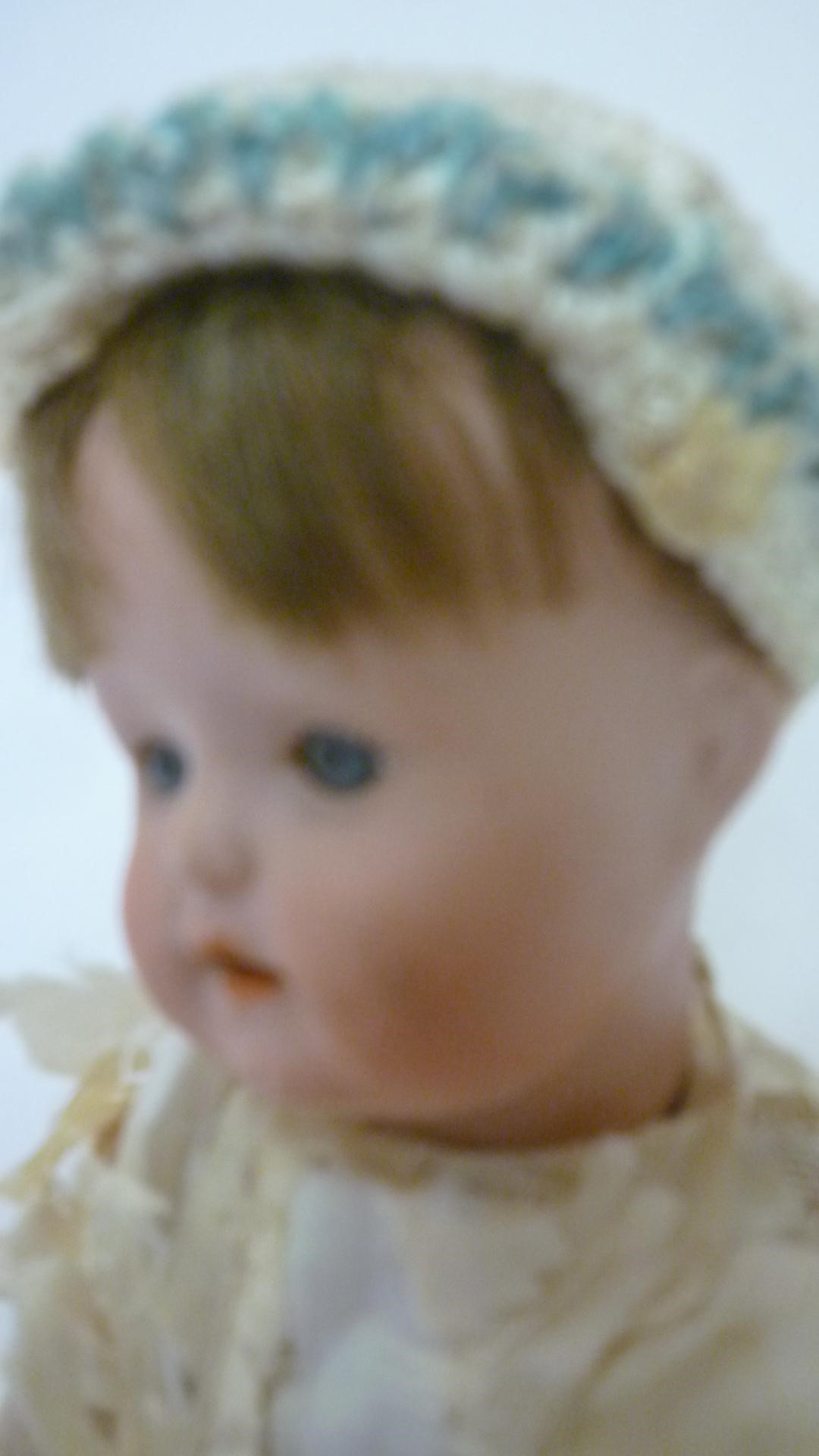A small German bisque head doll with blue glass sleeping eyes Image