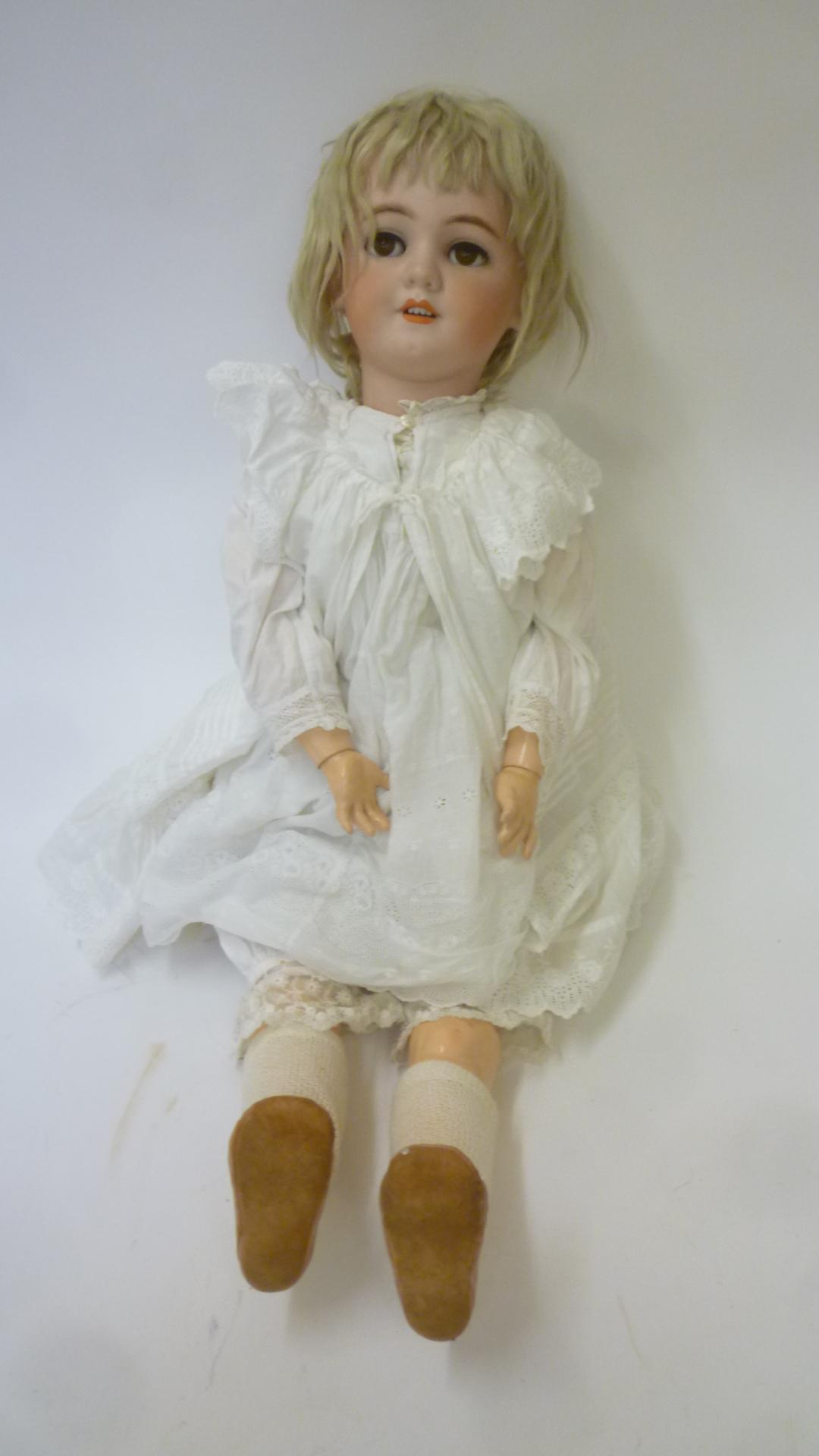 A Simon & Halbig bisque head doll with brown glass sleeping eyes Image