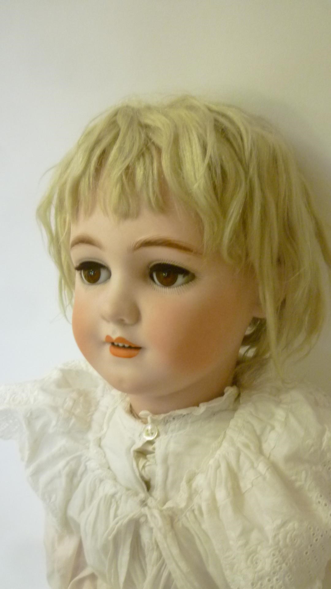 A Simon & Halbig bisque head doll with brown glass sleeping eyes Image