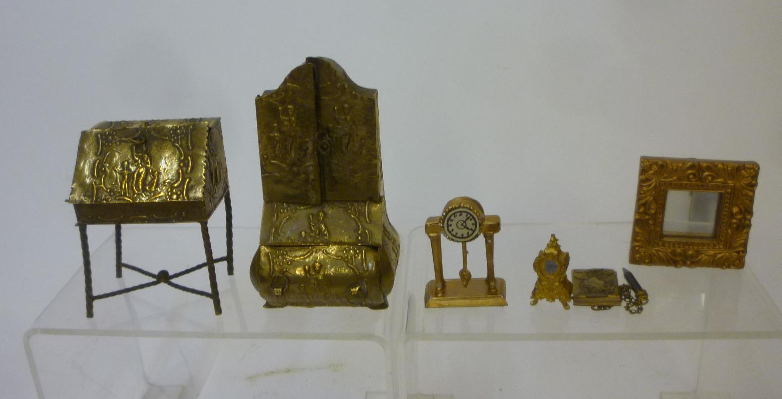 Two embossed brass dolls house furniture items comprising a Dutch style bureau bookcase and a lady's Image