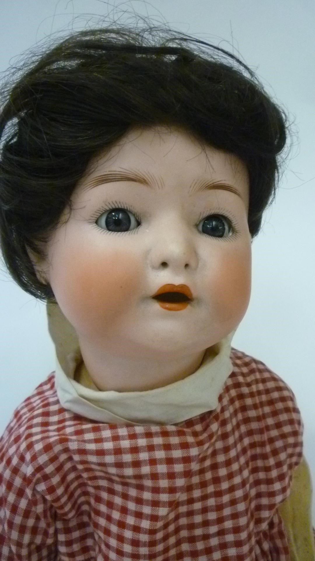 An Ernst Heubach bisque head doll with blue glass sleeping eyes and open mouth Image